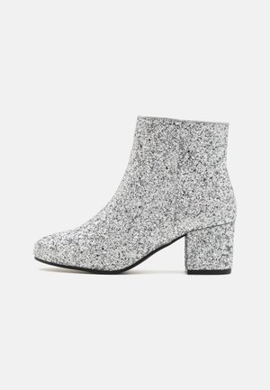 Silberne Glitzer-Ankle-Boots mit runder Zehenpartie, Blockabsatz und glatter Textur. Wassert eine schimmernde Oberfläche ohne sichtbare Beschläge.
