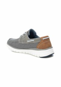 Zapatos informales en tonos gris y marrón con un upper de lienzo texturizado, suela de goma blanca y detalles de costura en contraste, que presentan un diseño de cordones.
