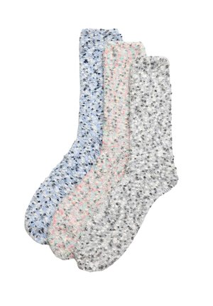 Tres pares de calcetines de diseño en azul claro con manchas oscuras, rosa con manchas grises y gris con manchas negras, que presentan una textura suave y peluda.