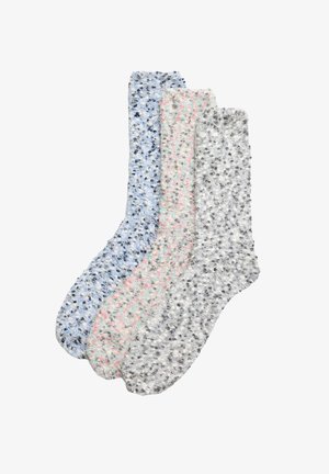 Tres pares de calcetines de diseño en azul claro con manchas oscuras, rosa con manchas grises y gris con manchas negras, que presentan una textura suave y peluda.