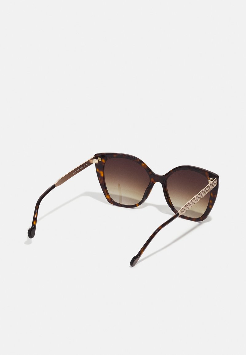 Katzenaugen-Sonnenbrille mit einem braunen Schildpattgestell, Verlaufsgläsern und goldenen Akzenten an den Bügeln. Strukturiertes Detail an den Tempeln.