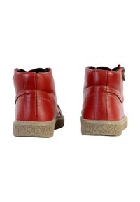 Scarpe alte in pelle rossa con texture liscia, dotate di suola in gomma beige e dettagli di cucitura sottili. Chiusura con cerniera laterale per una facile vestibilità.