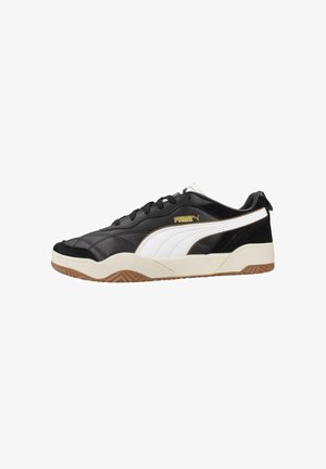 Baskets noires Puma avec bande latérale blanche, semelle gomme, lacets noirs et logo Puma doré sur le côté, vues du côté extérieur.