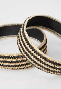 Woven black and tan striped hairbands with a smooth inner lining. Each band features a durable, textured design.