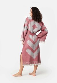 Dlhý rúžový župan so šikmým vzorom v sivej farbe, s širokými rukávmi, opaskom v oblasti pása a strapcami na leme.