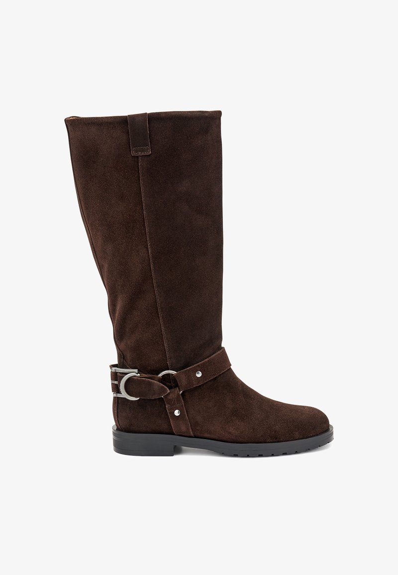 Bota de ante marrón hasta la rodilla con suela plana, detalle de correa con hebilla y costuras mínimas. Presenta un acabado suave y texturizado.