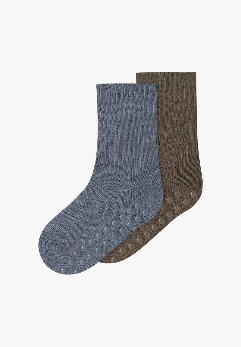 Deux paires de chaussettes en coton : une bleue, une marron. Les deux présentent une bande côtelée au niveau du haut et des points en caoutchouc sous la semelle pour l'adhérence.