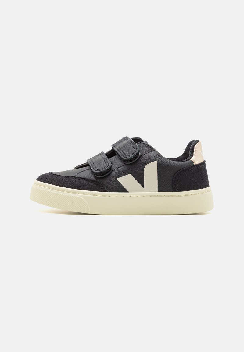 Black leather sneakers with Velcro straps, beige sole, and a textured black accent at the toe. Features a prominent white logo on the side.