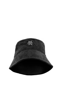 Black corduroy bucket hat with a wide brim, featuring a small embroidered logo on the front. Textured fabric with a smooth interior.