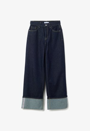 Jeans in denim blu scuro a gamba larga con orli ripiegati che rivelano un denim più chiaro e cuciture visibili, dotati di tasche frontali e passanti per cintura.