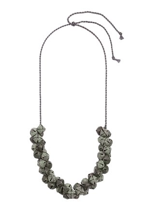 Naszyjnik wykonany z małych metalowych dzwoneczków nawleczonych na skręcony szary sznurek z zawiązanym pętelkowym zapięciem.