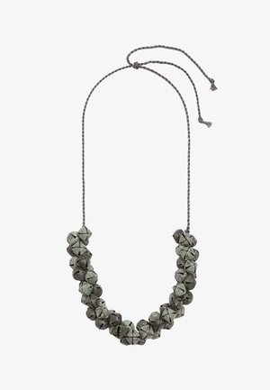 Naszyjnik wykonany z małych metalowych dzwoneczków nawleczonych na skręcony szary sznurek z zawiązanym pętelkowym zapięciem.