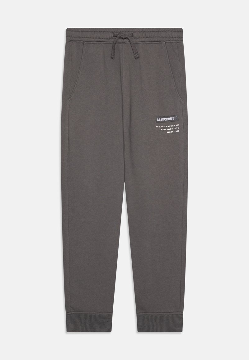Pantalon de survêtement gris avec une taille élastique et un cordon de serrage. Comprend des poches latérales et un logo imprimé blanc sur la cuisse gauche. Poignets côtelés.
