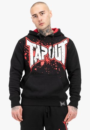 Black hoodie featuring a white and red "TAPOUT" logo with splatter design. Made from soft material, it has a front pocket and drawstring hood.