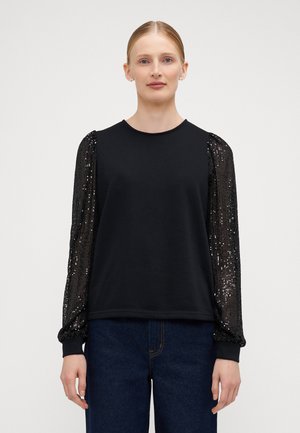 Black long-sleeve top with soft fabric body and sequin-embellished puffed sleeves. Round neckline and elastic cuffs. Worn with blue denim.