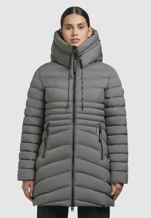 Manteau d'hiver gris en duvet avec un col haut, motif en chevrons, deux poches latérales zippées et des cordons de serrage. Tissu lisse et isolé.