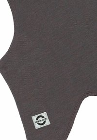 Brunt tekstilbeklædning med en blød tekstur, der har et karakteristisk snit og logo-patch. Glat finish og ensartet farve hele vejen igennem.