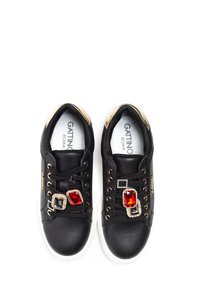 Black leather sneakers with gold accents, featuring jeweled embellishments in red and black, white rubber soles, and black laces.