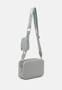 Borsa a tracolla grigia realizzata in materiale testurizzato. Presenta una forma rettangolare piatta, chiusura con zip e una piccola pochette staccabile attaccata alla tracolla.