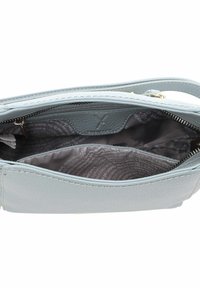 Interior de un bolso de mano de cuero azul claro con un bolsillo con cremallera, con un forro gris que presenta patrones de texto sutiles y un diseño de compartimentos divididos.
