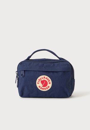 Bolsa rectangular pequeña de color azul marino con cremallera, asa superior y logo redondo rojo y blanco de Fjällräven Kånken en el bolsillo frontal.