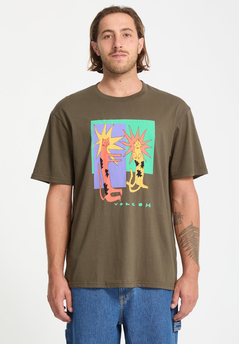 Brun bomulds t-shirt med grafik af to stiliserede katte med klare gule og orange accenter mod en multifarvet baggrund.