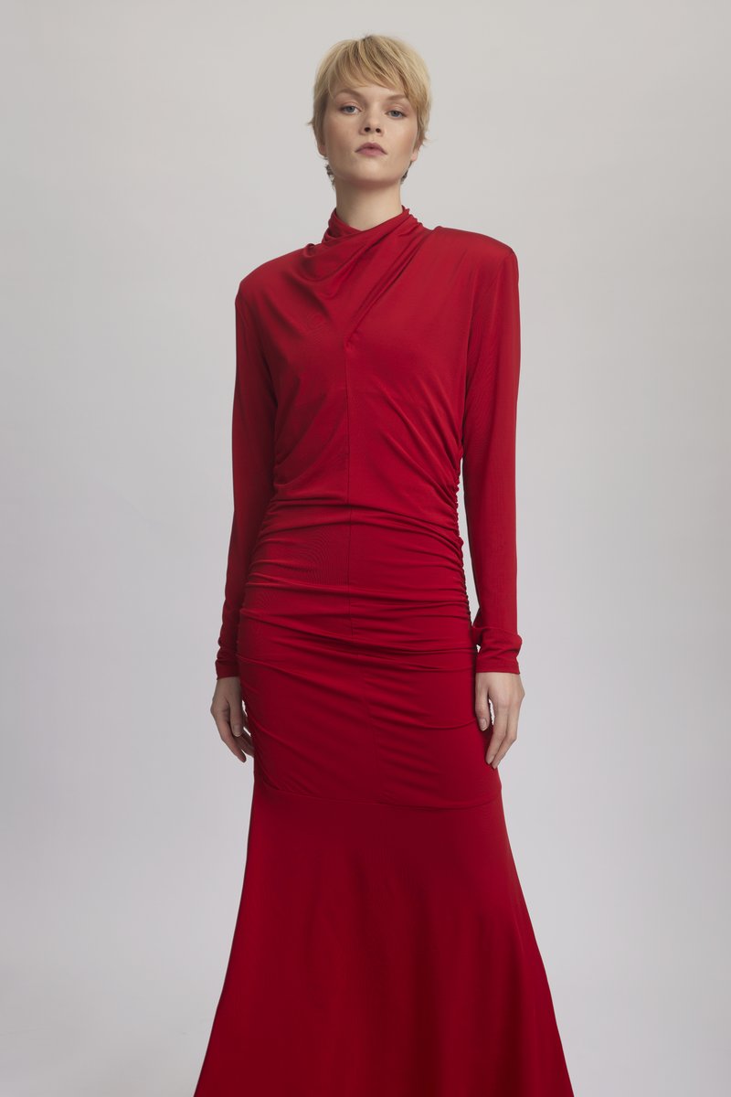 Κόκκινο φόρεμα με μακριά μανίκια και ψεύτικο λαιμό, με πλισέ λεπτομέρειες και εφαρμοστό μπούστο που καταλήγει σε φουσκωτό τελείωμα. Λείος και ελαστικός ύφασμα.