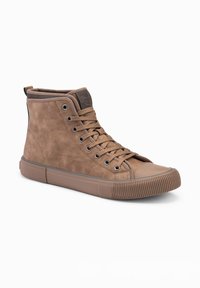 Zapatillas altas marrones de ante con puntera redonda, suela de goma y acentos de textil en contraste. Presenta cordones y detalle del logo en la lengüeta.
