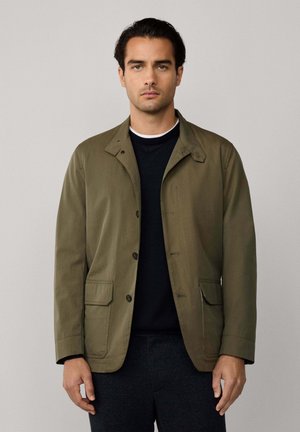 Olivgrüne Jacke mit strukturiertem Kragen, Frontknöpfen und zwei Seitentaschen; glatte Textur und leicht lockere Passform.
