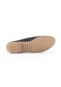 Semelle de chaussure plate Gabor, en caoutchouc beige avec un motif de grip texturé. Dessus noir épuré avec des détails textiles subtils. Fini lisse, design minimal.