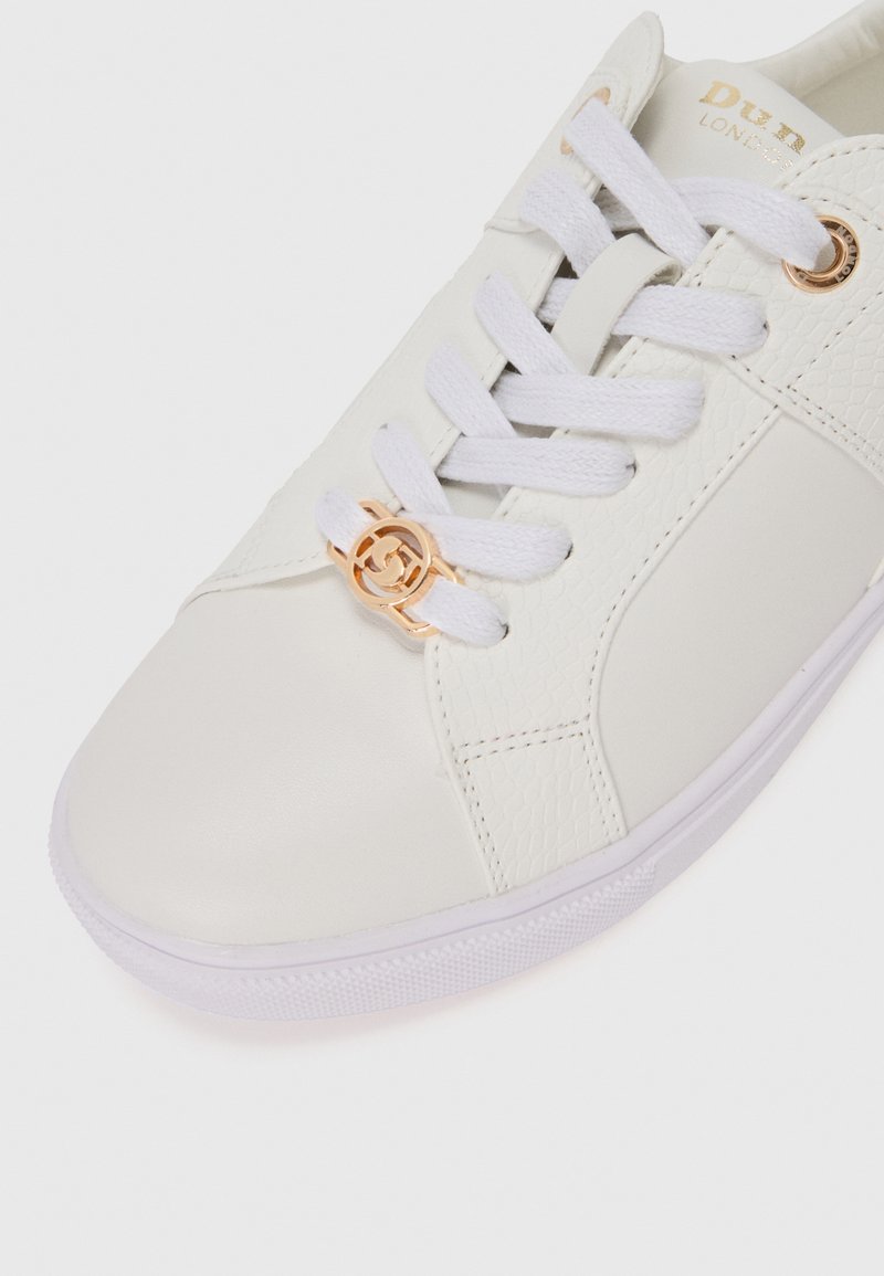 Białe skórzane sneakersy z teksturowanym panelem, białymi sznurowadłami i złotym detalem logo przy sznurowaniu. Posiadają gumową podeszwę i przeszywane akcenty.