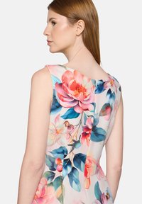 Robe fleurie à coupe ajustée, présentant de grands motifs floraux roses et bleus sur un fond clair. Tissu lisse et encolure dégagée.