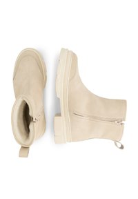 Beige suède enkellaarzen met dikke zolen, een zijrits en een warme fleece voering, weergegeven vanuit boven- en zijaanzicht op een witte achtergrond.