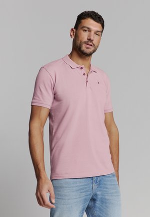 Lichtroze polo met een klassieke kraag, korte mouwen en een twee-knoopsluiting; heeft een klein logo en is gemaakt van zacht, ademend materiaal.