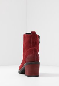Rote Wildleder-Chelsea-Stiefel mit Blockabsatz, Reißverschluss hinten und robuster strukturierter Sohle. Mit einem Zuglasche für einfaches Anziehen.