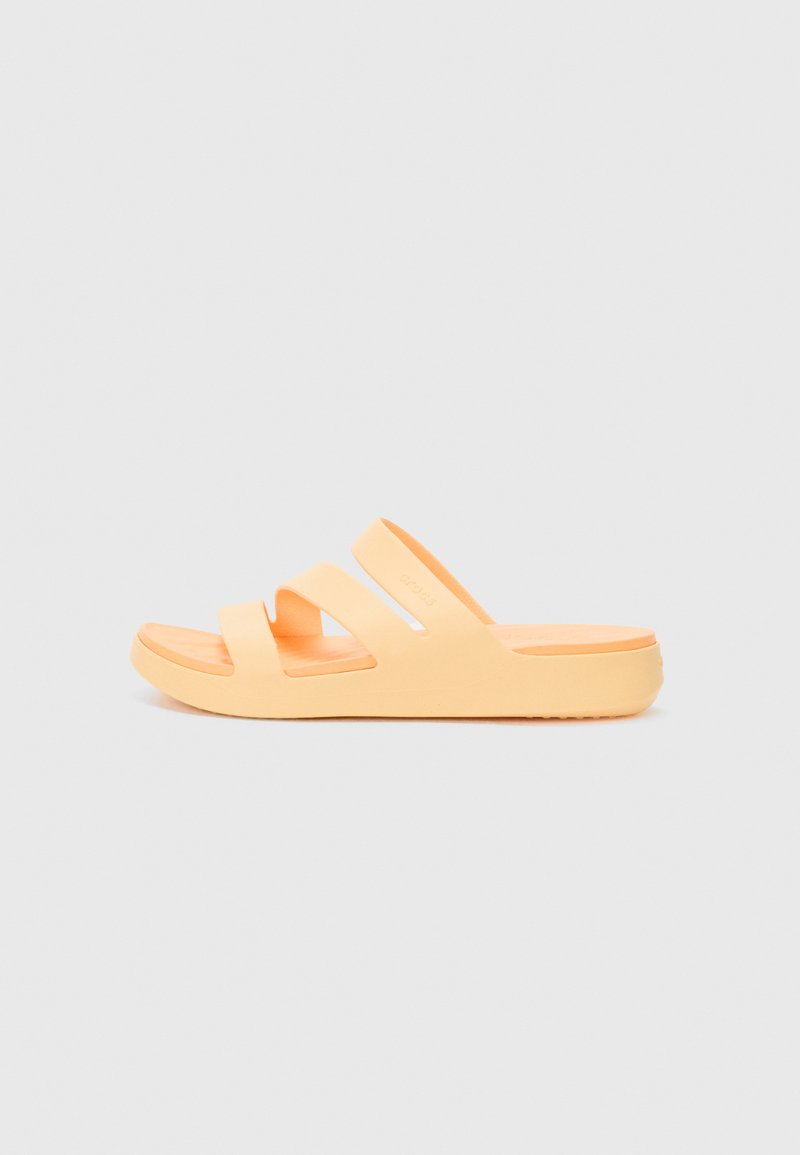 Orange rubber slide sandal with two wide straps, a flat sole, and textured surface, featuring an open toe design and a modern silhouette.