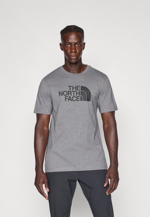 Grey t-shirt featuring "THE NORTH FACE" logo in black, round neckline, short sleeves, and a soft, lightweight cotton material.