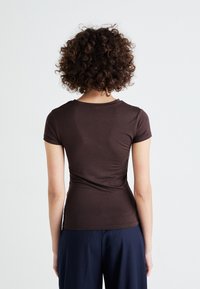 Brown short-sleeve t-shirt, fitted design with soft, stretchy material. Features a classic crew neckline and a smooth, seamless back.
