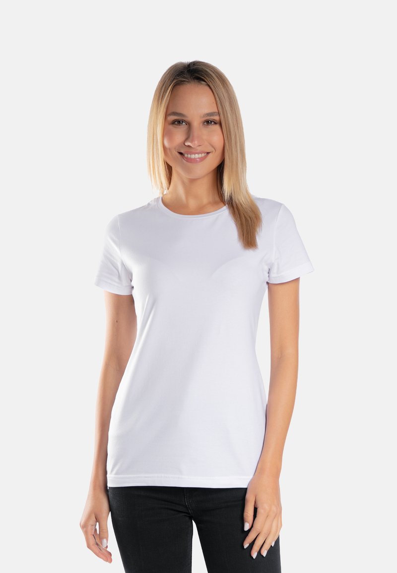 Biała bawełniana koszulka z krótkim rękawem, okrągłym dekoltem i dopasowanym krojem, noszona z czarnymi dżinsami. Gładka faktura, brak widocznych wzorów.