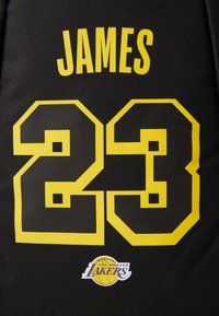 Zwart Los Angeles Lakers jersey met gele "JAMES" naam, nummer 23 in zwart omrand met geel, en Lakers logo onder het nummer.