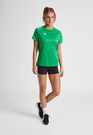 T-shirt de sport vert à manches courtes, texture lisse, et shorts noirs contrastés. Comprend un détail de logo sur la poitrine et l'épaule.