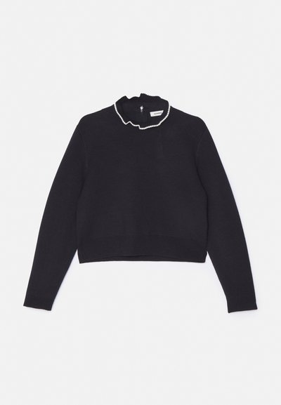 Sort cropped sweater, strikstruktur, lange ærmer, flæsedetalje ved kraven med en perleaccent, lynlås lukning bagpå.