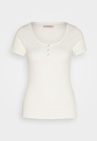 Valkoinen, lyhythihainen t-paita, valmistettu ribbineuloksesta. Edessä pyöreä pääntie ja kolme painonappia. Yksinkertainen ja istuva malli.