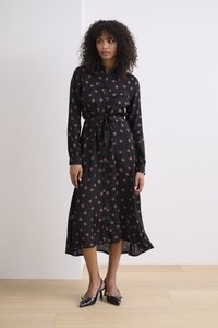 Schwarzes Hemdkleid mit pinken Punkten, langen Ärmeln, Taillengürtel und Midi-Länge, mit einem fließenden Design und glatter Textur.