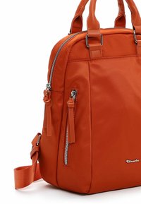 Orange nylon handbag with double handles, adjustable shoulder strap, silver hardware, zippered pockets, and smooth texture.