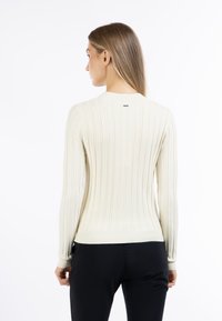 Maglione bianco a coste con maniche lunghe, scollatura rotonda e vestibilità slim. Presenta dettagli sottili sulla schiena e una texture elastica.