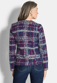 Gestickter Pullover mit einem strukturierten karierten Muster in Blau, Rot und Grau. Mit Rundhalsausschnitt und langen Ärmeln. Rückansicht angezeigt.