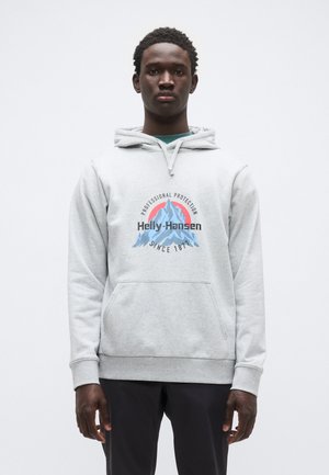 Svetlosivá mikina s kapucňou, predným vreckom kangaroo, sťahovacou šnúrkou na kapucni a potlačeným logom "Helly Hansen" s horskou grafikou.