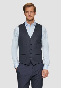 Marineblauwe gebloemde gilet met vijf knopen, twee voorzakken en een slank ontwerp, gecombineerd met een lichtblauw overhemd en donkere broek.