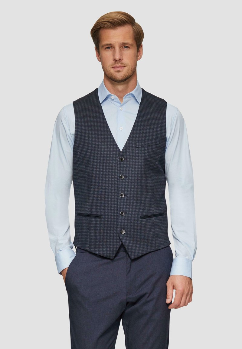 Marineblauwe gebloemde gilet met vijf knopen, twee voorzakken en een slank ontwerp, gecombineerd met een lichtblauw overhemd en donkere broek.